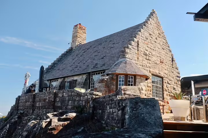 Historic stone building atop Table Mountain offering panoramic views, part of the cable car experience in Cape Town.