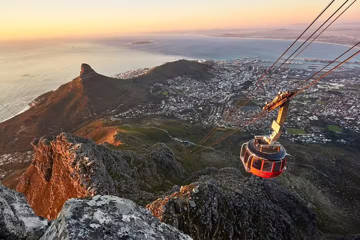 Aerial view of Table Mountain cable car at sunset, overlooking Cape Town and ocean vistas on a guided full day tour.