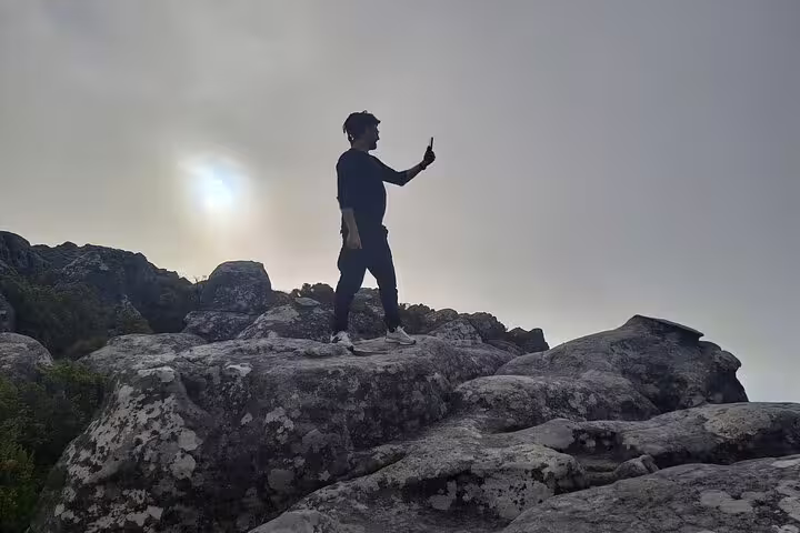 Traveler capturing stunning views atop Table Mountain, showcasing the breathtaking landscape and adventure.