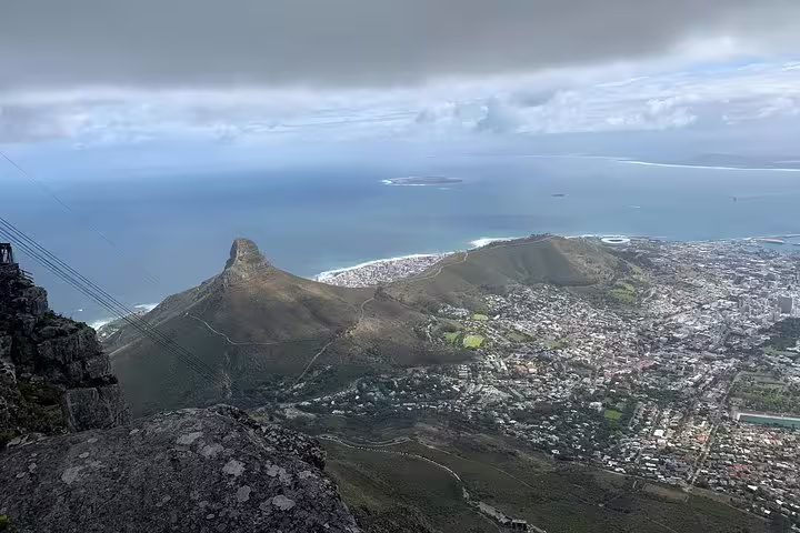 Panoramic view from Table Mountain showcasing Lion's Head, Cape Town cityscape, and the Atlantic Ocean's expanse.