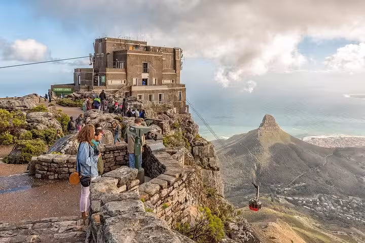 Tourists enjoy panoramic views from the summit of Table Mountain overlooking Cape Town and Lion's Head.