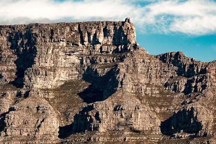 Majestic view of Table Mountain's rocky cliffs under a clear sky, a highlight of the Cape Town tour to Cape Point and Boulders Beach.