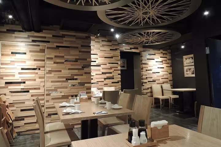 Cozy dining setup at Taipei Hungzhou Xiaolongbao, highlighting elegant wooden furniture and contemporary wall art.
