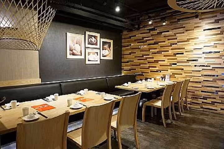 Chic seating arrangement at Taipei Hungzhou Xiaolongbao featuring wooden design and artistic wall decor for a refined dining experience.