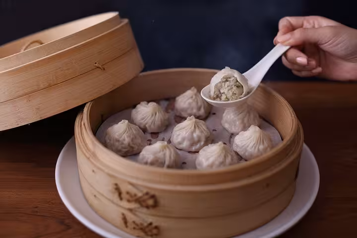 Steaming bamboo basket of juicy pork xiaolongbao dumplings at Taipei Hungzhou Xiaolongbao restaurant.