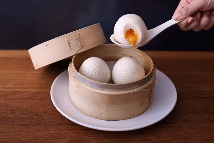 Golden custard-filled steamed buns served in a bamboo basket for a unique dining experience in Taipei.