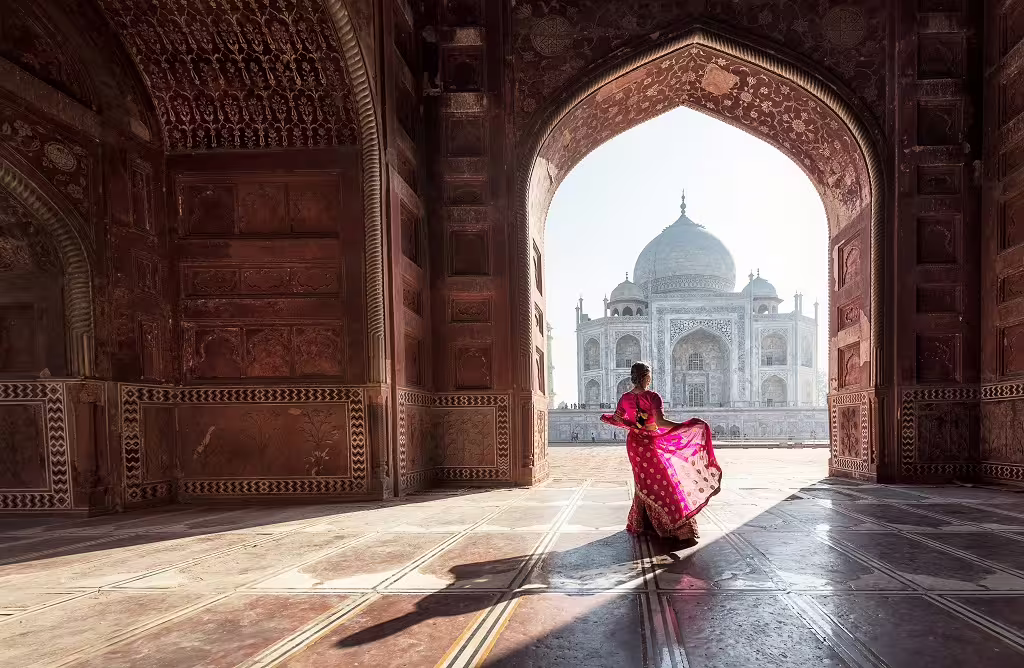 Discover the Taj Mahal's majestic beauty framed by intricate archways, a highlight of the Classic Golden Triangle tour.
