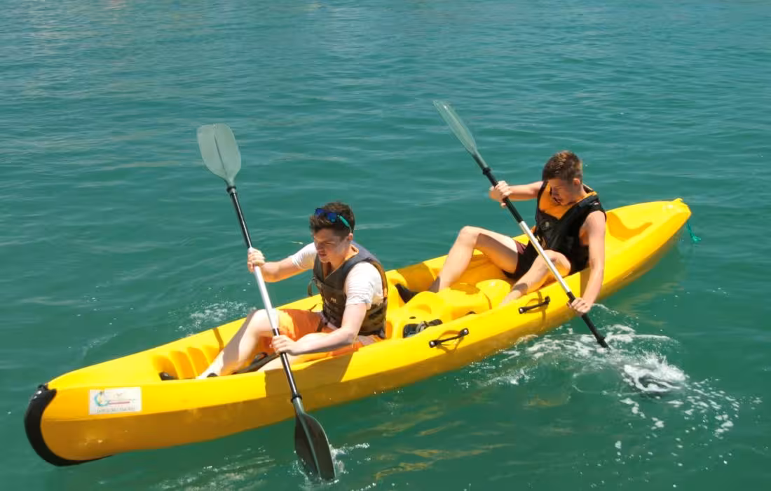 Two people paddling a tandem kayak on clear blue water, perfect for a 4-hour kayak rental and sea kayaking