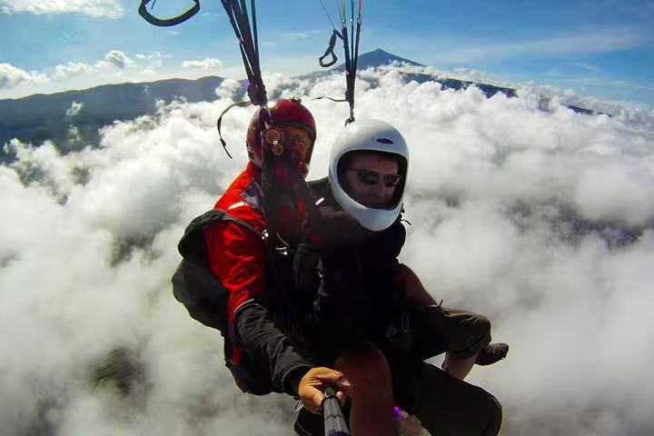 Experience tandem paragliding at 2250 meters above clouds with stunning mountain views, perfect for adventure seekers.