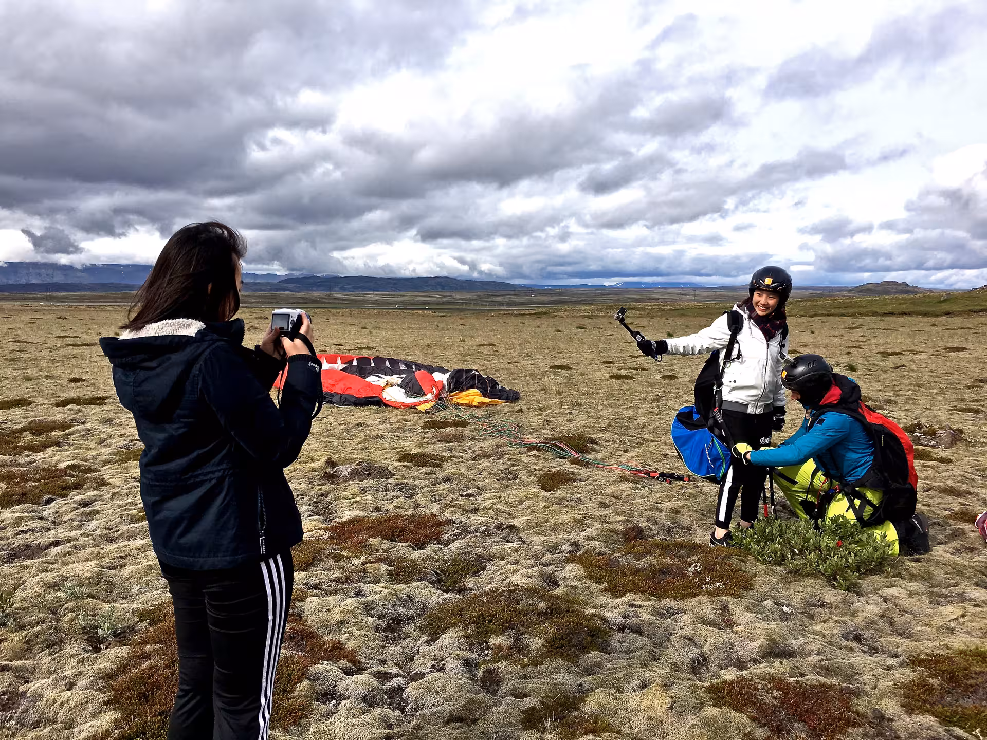 Tandem paragliding over Blue Mountains lava fields, smiling flyer in helmet with sweeping volcanic views