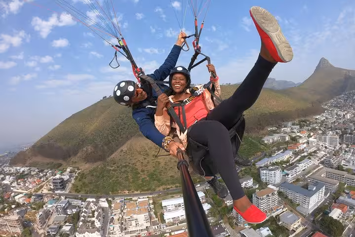 Joyful tandem paragliding adventure over Cape Town with stunning mountain and city views.