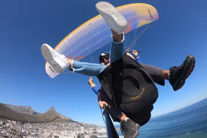 Thrilling tandem paragliding experience over Cape Town's scenic coastline and vibrant cityscape.