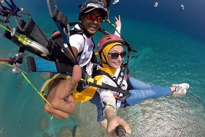Tandem parasailing selfie above turquoise Red Sea in Sharm El Sheikh, includes private transfer and pickup