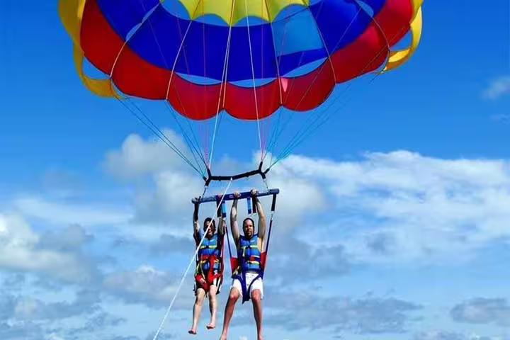 Tandem parasailing in Sharm El Sheikh with colorful canopy, soaring high above the Red Sea under blue sky