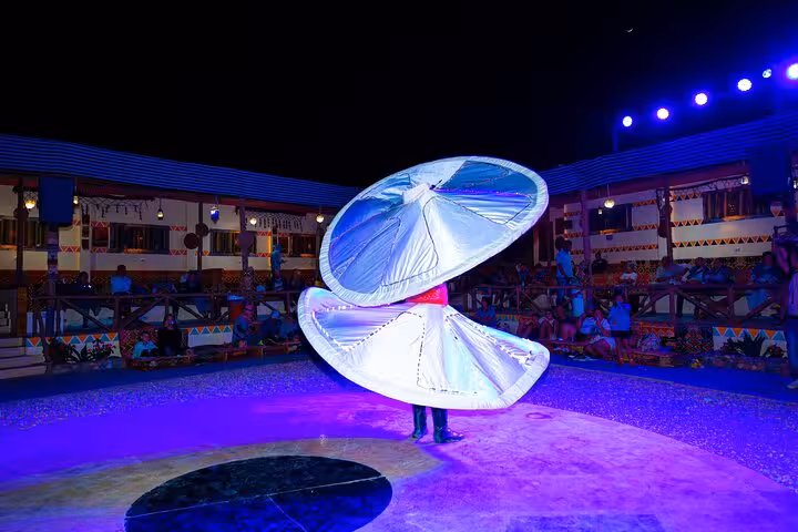 Tanoura dancer spinning under stage lights at Viva Safari dinner show, part of quad and Spider Car tour