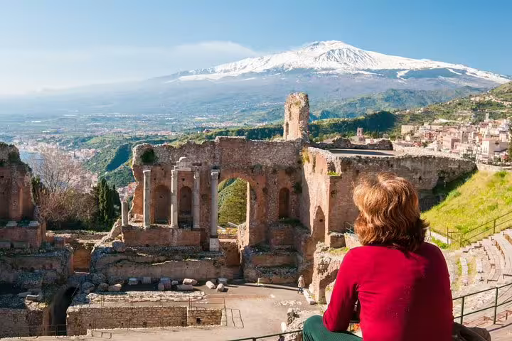 Traveler admiring Taormina’s ancient Greek Theatre with panoramic views of Mount Etna on a private sightseeing tour in Sicily