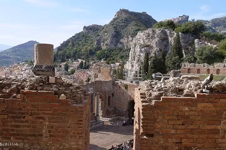 Ruins of the ancient Greek Theatre in Taormina offer stunning views of the surrounding hills, a highlight of the tour.