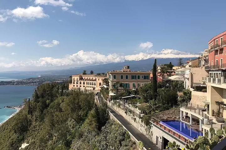 Panoramic view of Taormina’s coastline and Mount Etna from hillside villas, featured on a private Etna and Taormina tour from Cefalù