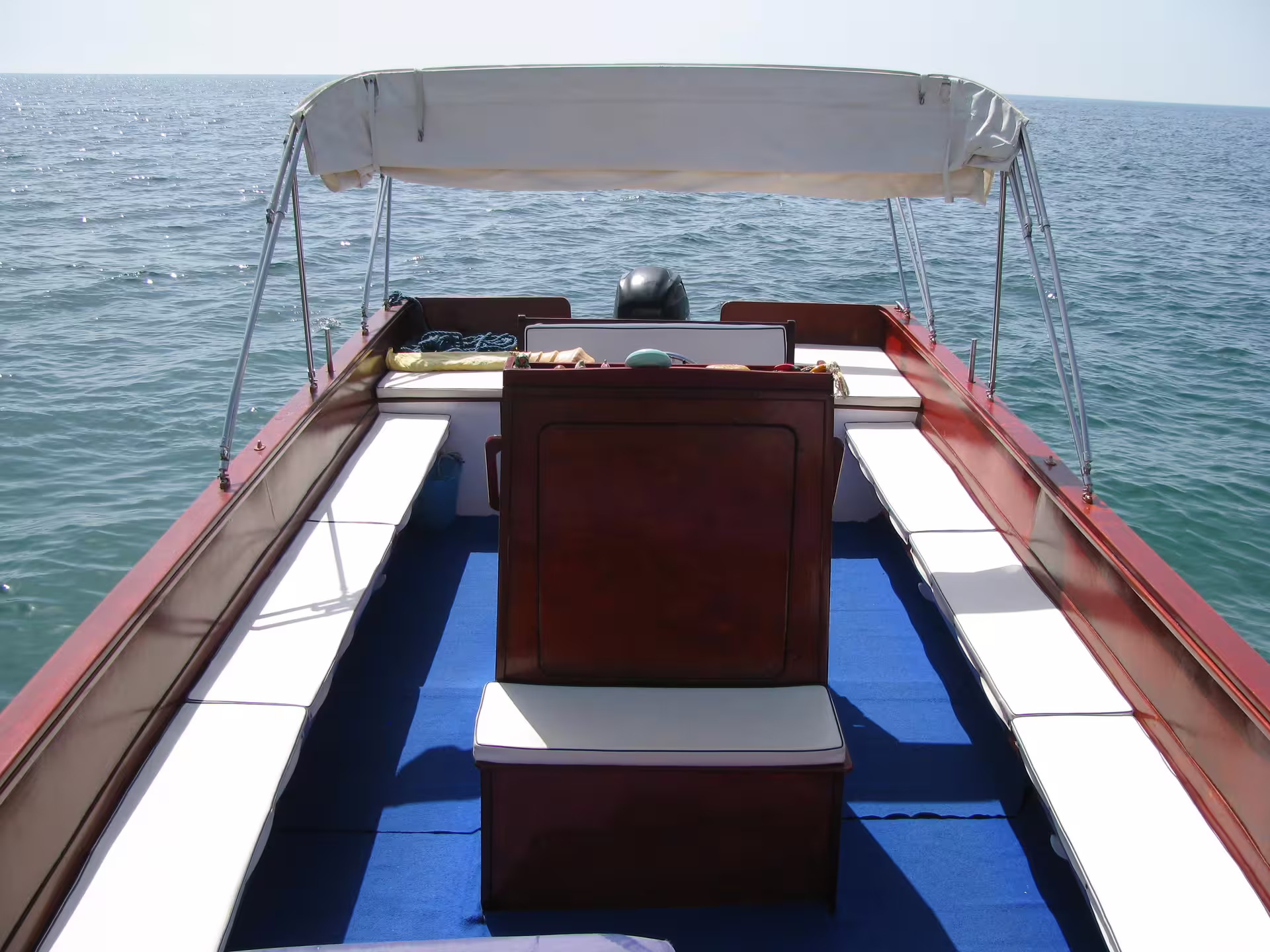 Seating area on a private Taormina boat tour, shaded canopy and benches cruising the Ionian Sea Sicily