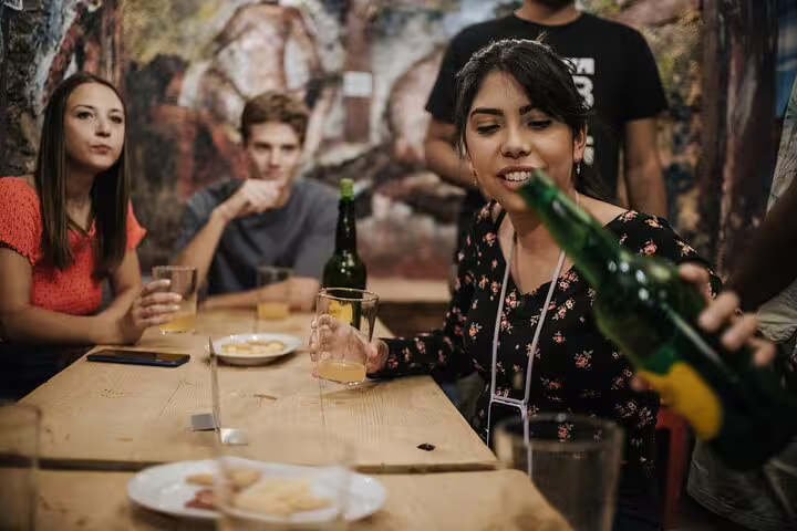 Group enjoying traditional tapas and drinks at a lively Madrid bar, capturing the essence of Spanish culinary culture.