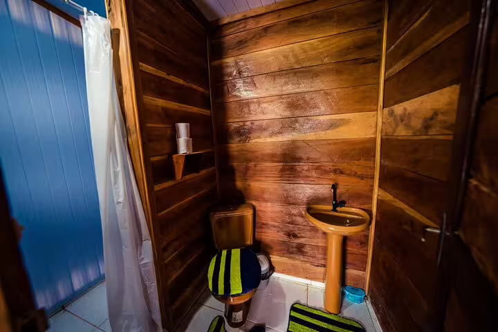 Rustic bathroom with wooden walls and modern amenities at Tapiri Rio Negro Lodge jungle retreat.
