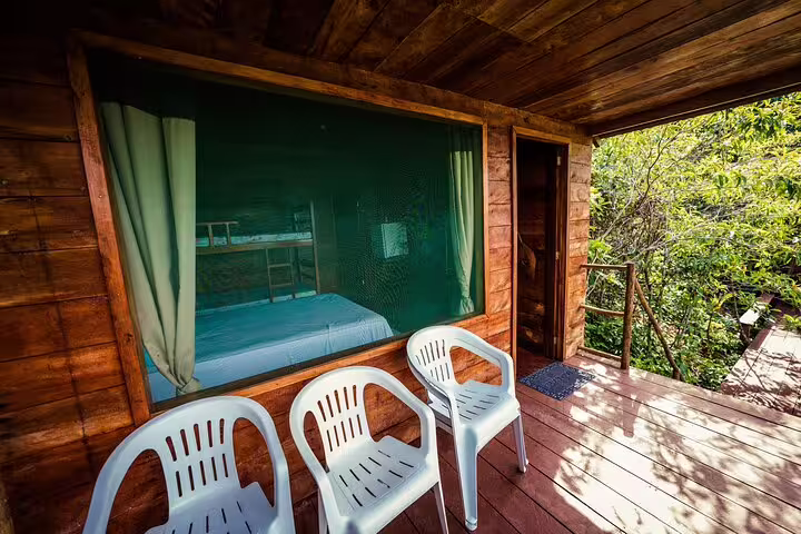 Wooden deck with chairs and a jungle view at Tapiri Rio Negro Lodge, offering serene forest accommodations.
