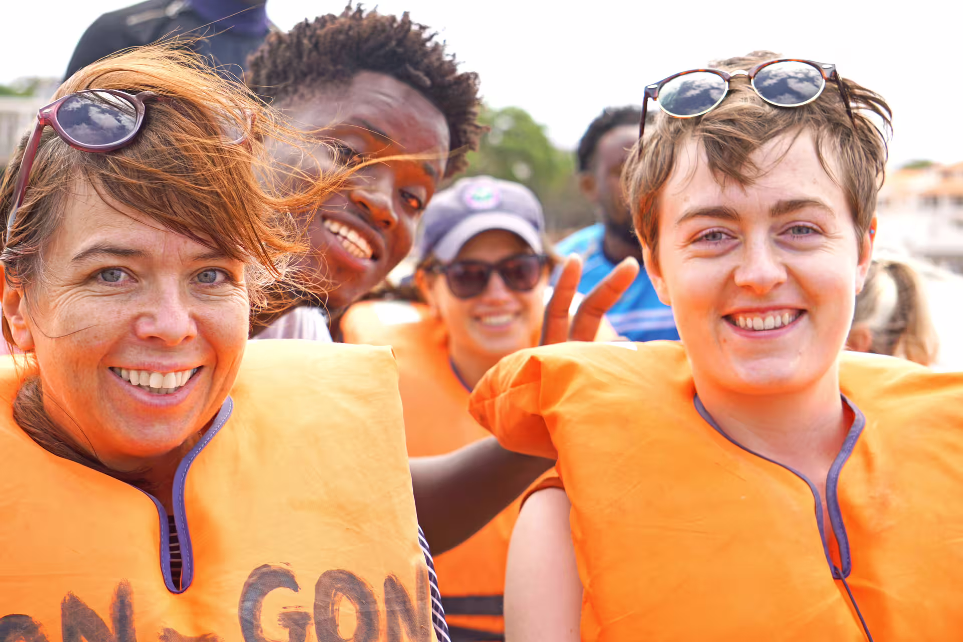 Smiling group in life jackets enjoying a sunny boat trip on Tarrafal Beach tour.