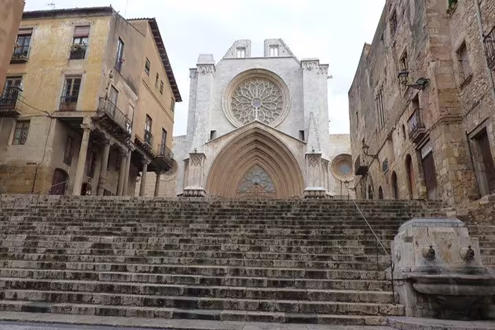 Visit the majestic Tarragona Cathedral, showcasing Gothic architecture with impressive stone steps and intricate rose window.