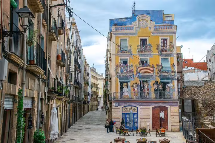 Colorful mural facade on a narrow Tarragona old town street, ideal stop on a self-guided scavenger hunt tour