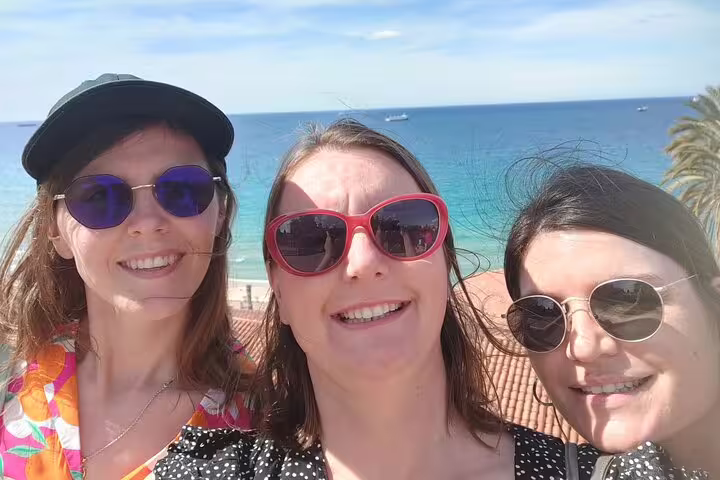 Friends taking a selfie with Tarragona beach and sea backdrop during a self-guided scavenger hunt tour