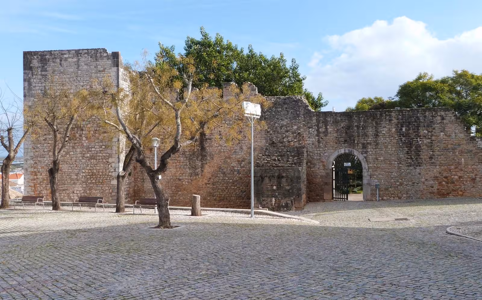 Medieval stone walls and quiet cobbled square of Tavira Castle in Algarve, Portugal, featured on The Secrets of the Leeward Islands tour