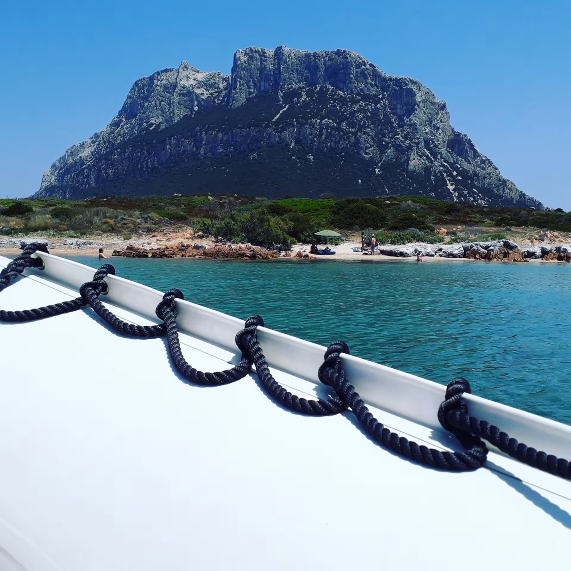 View of Tavolara Island from a boat, showcasing scenic coastline during Porto San Paolo tour.