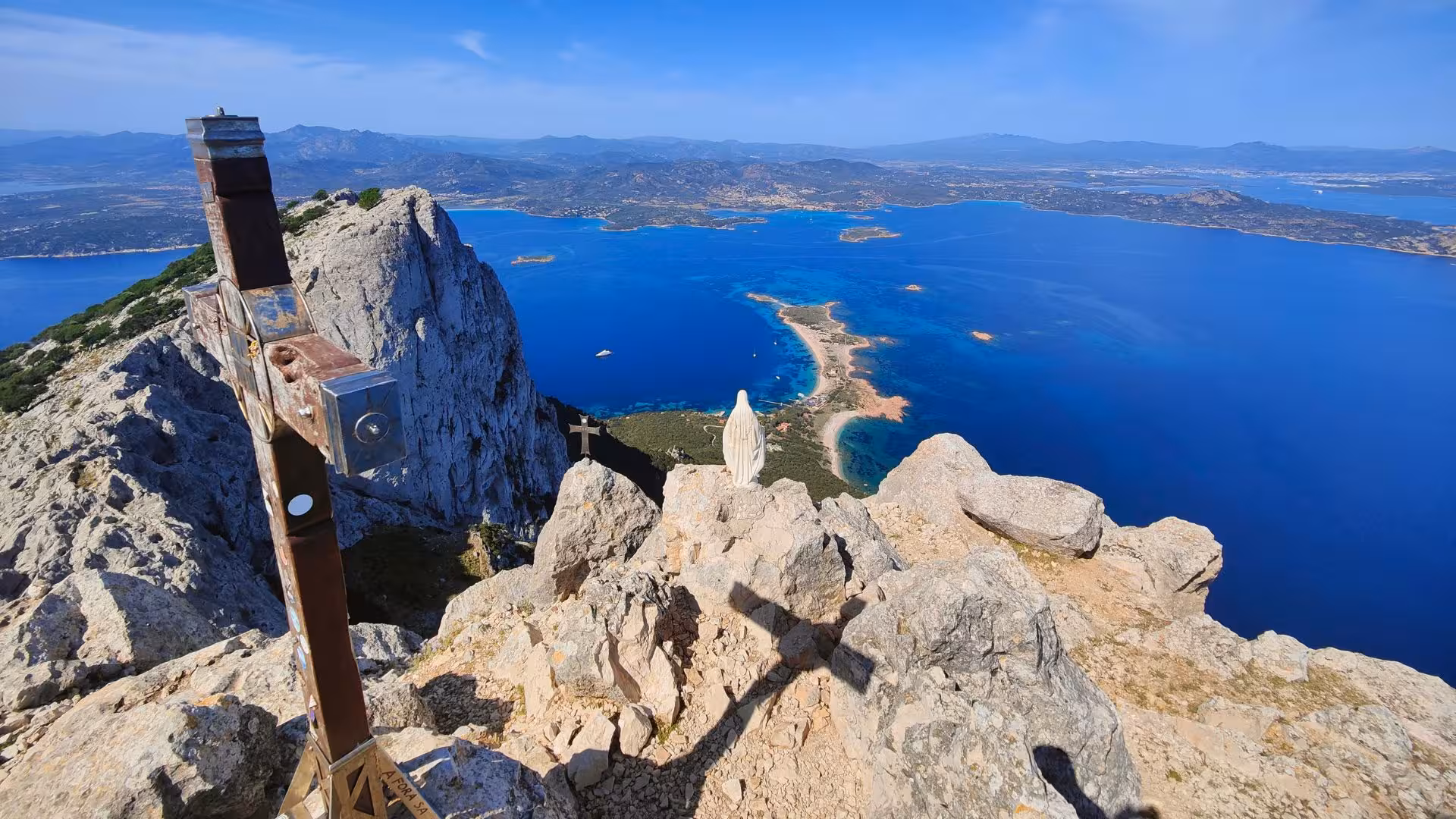 Panoramic vista of Tavolara Island's rugged cliffs and azure sea, perfect for adventurous Olbia trekking tours.