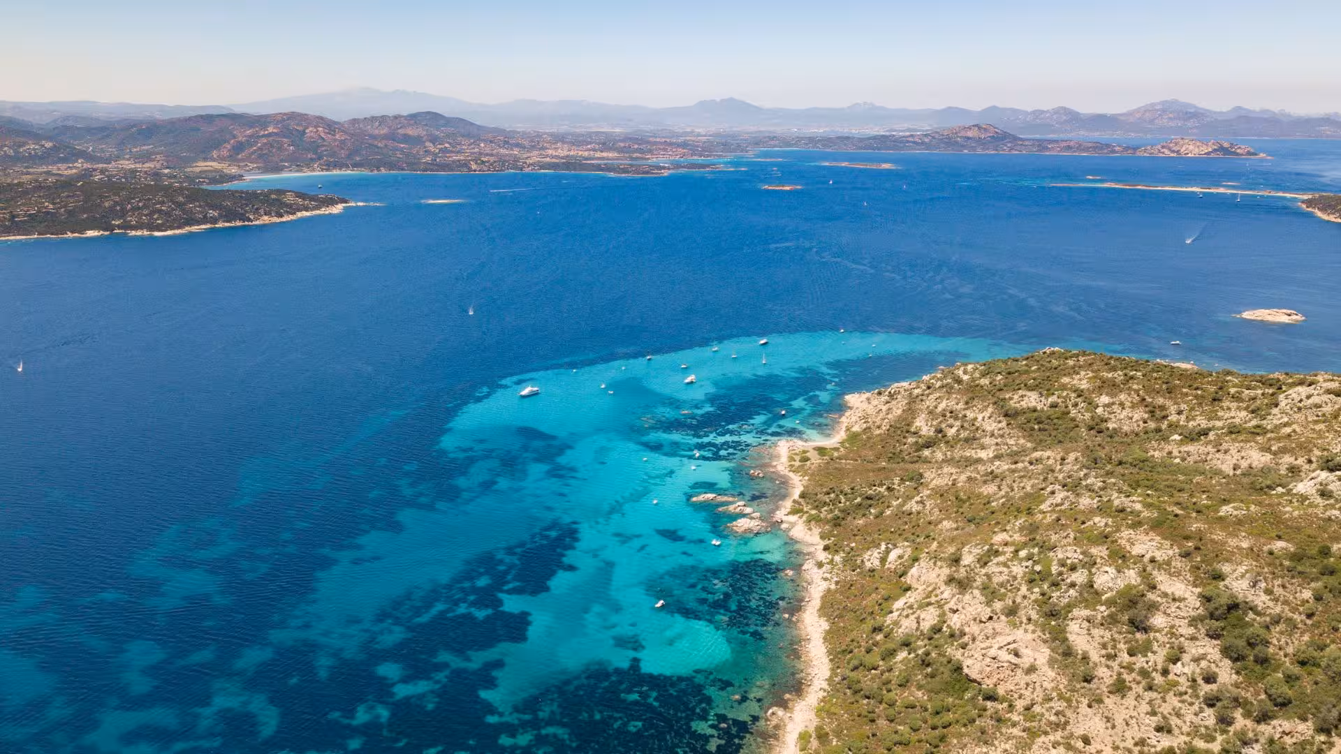 Aerial view of Tavolara Marine Area showcasing vibrant turquoise waters and scenic coastline, perfect for boat tours.