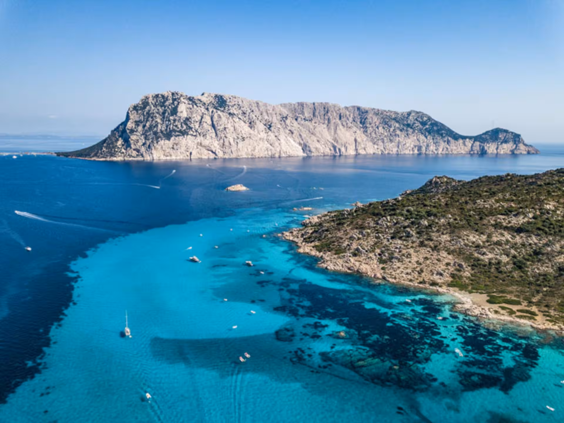 Aerial view of Tavolara Island's stunning turquoise waters, ideal for professional diving adventures.