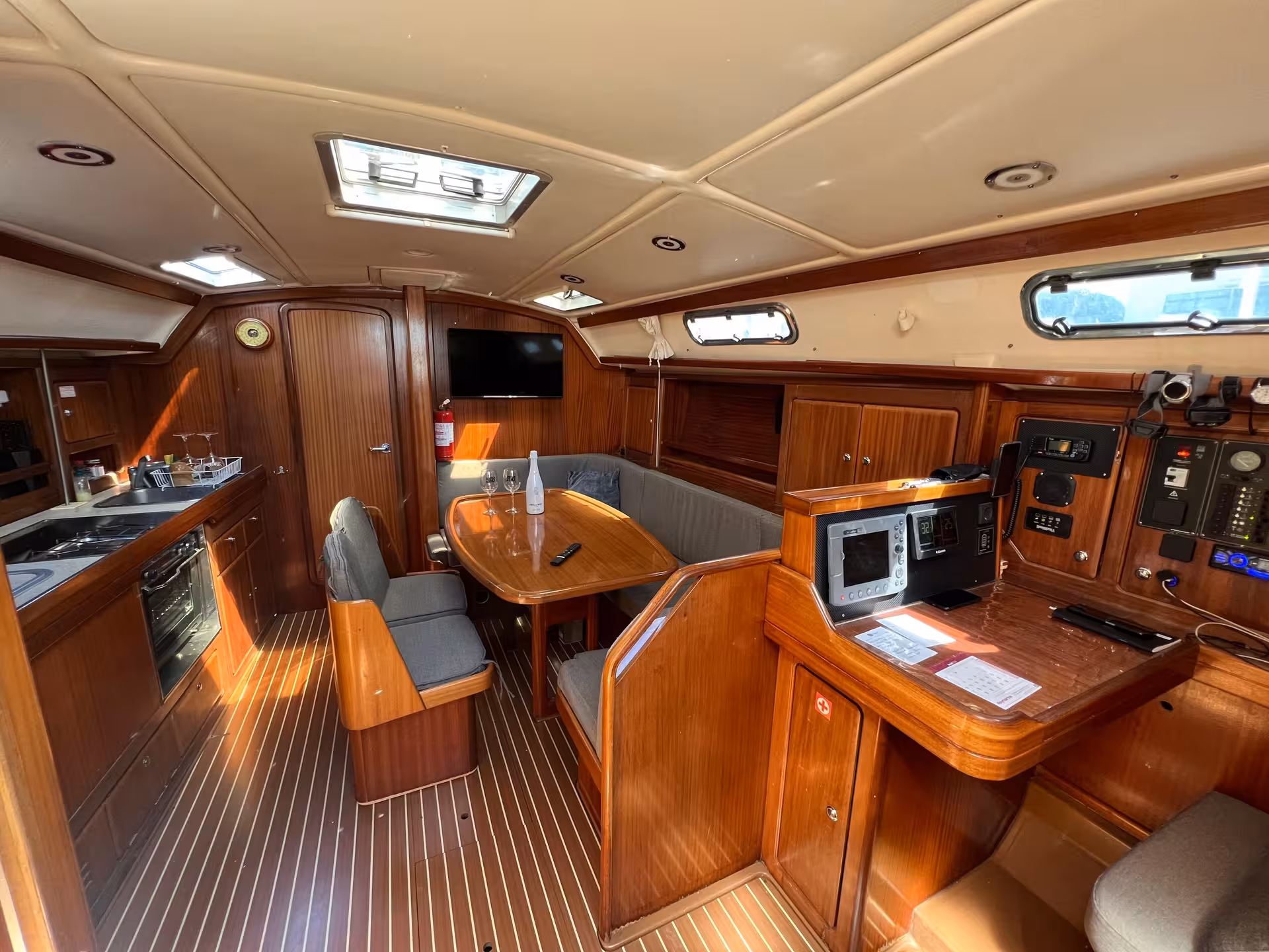 Warm teak yacht cabin interior with dining table and galley, Lagos Algarve sunset tour comfort and amenities