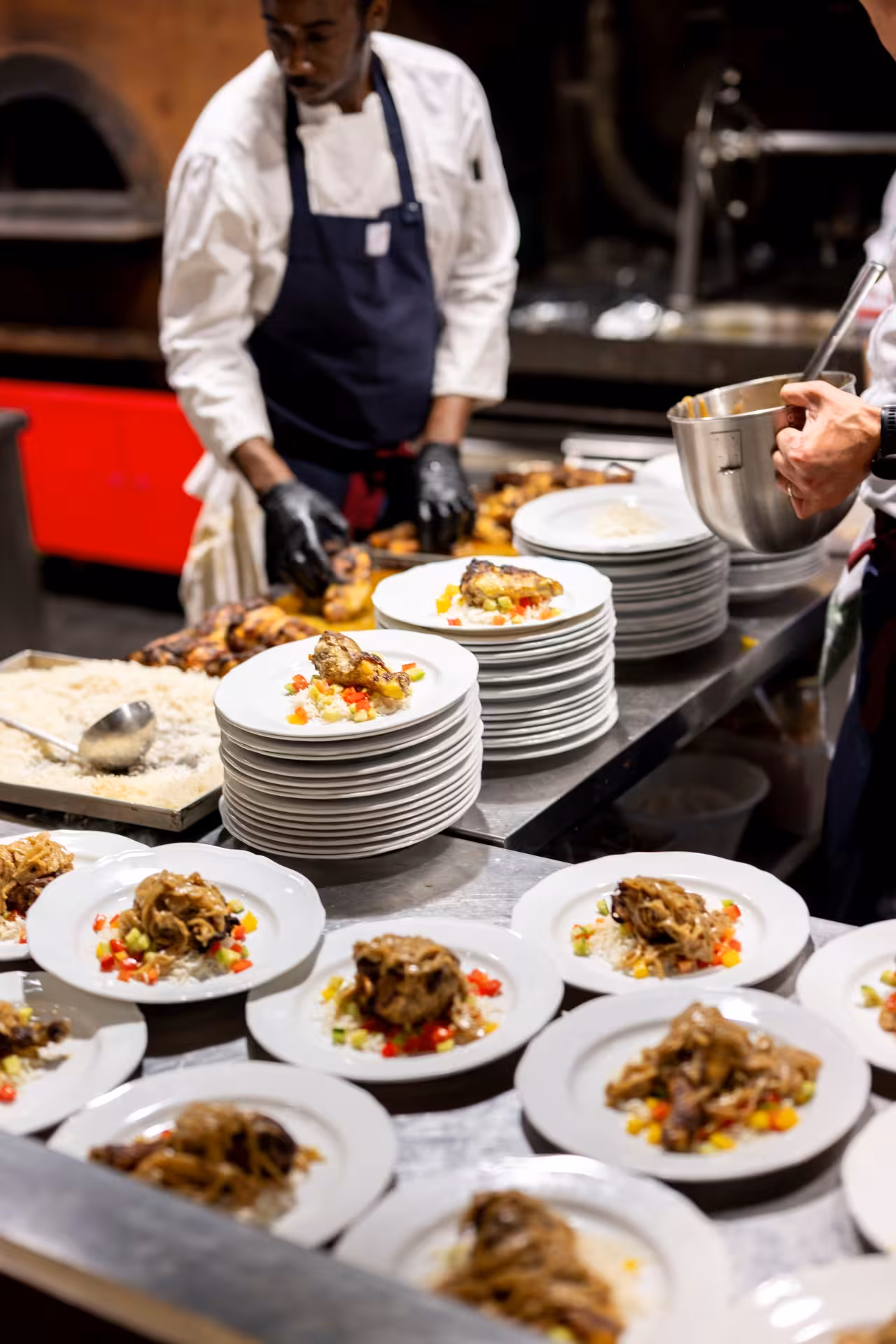 Kitchen plating Tuscan mains for Teatro del Sale Florence dinner and show, with chefs preparing fresh courses