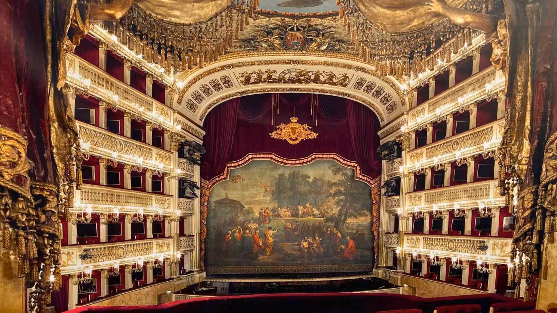Luxurious interior of Naples' Teatro di San Carlo with ornate balconies and a richly decorated stage.