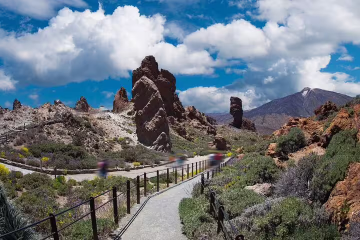 Scenic path leading through rocky landscapes in Teide National Park under a vibrant blue sky.