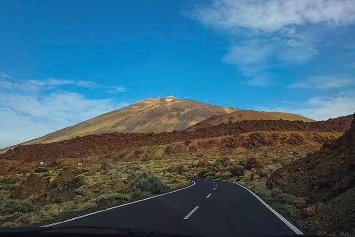 Scenic road leading to Mount Teide with vibrant blue skies in Teide National Park, ideal for nature tours.