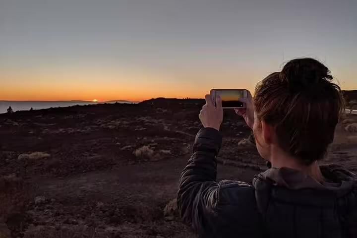 Traveler capturing a stunning Teide sunset on camera during an adventurous Quad Trip experience.