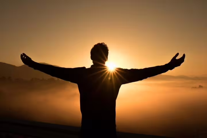 Silhouette of a person embracing the sunset on Teide Quad Trip, highlighting serene mountain landscape.