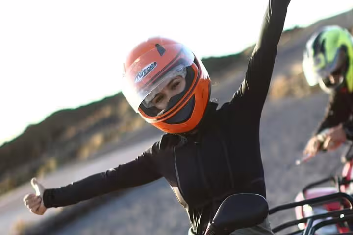 Adventurous rider on a Teide Sunset Quad trip, enjoying the thrill in scenic Tenerife with an orange helmet.
