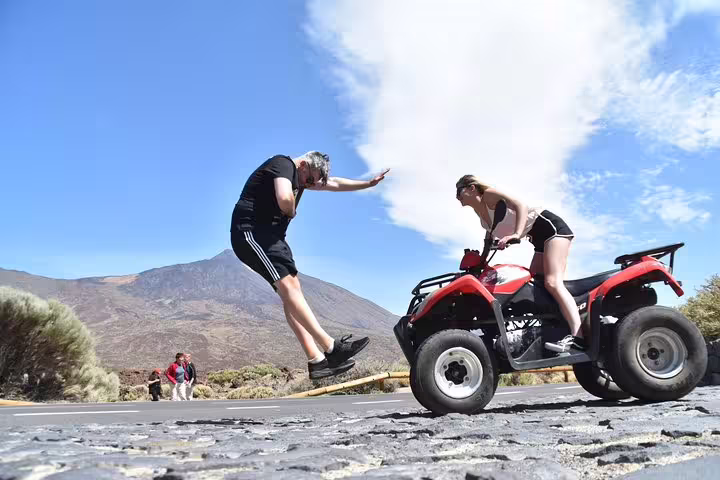 Adventurous couple enjoying quad biking near Teide Volcano, capturing dynamic fun against a volcanic backdrop.