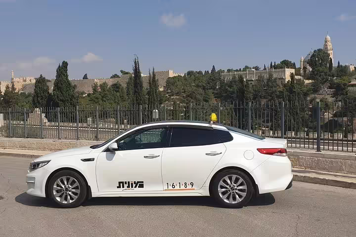 Private Tel Aviv day tour vehicle with Jerusalem skyline backdrop, en route to Nazareth, Tiberias and Galilee