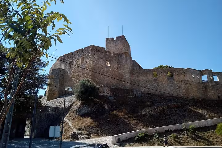 Explore the historic walls of the Templar Castle under a clear blue sky on a private 1 to 8 person tour.