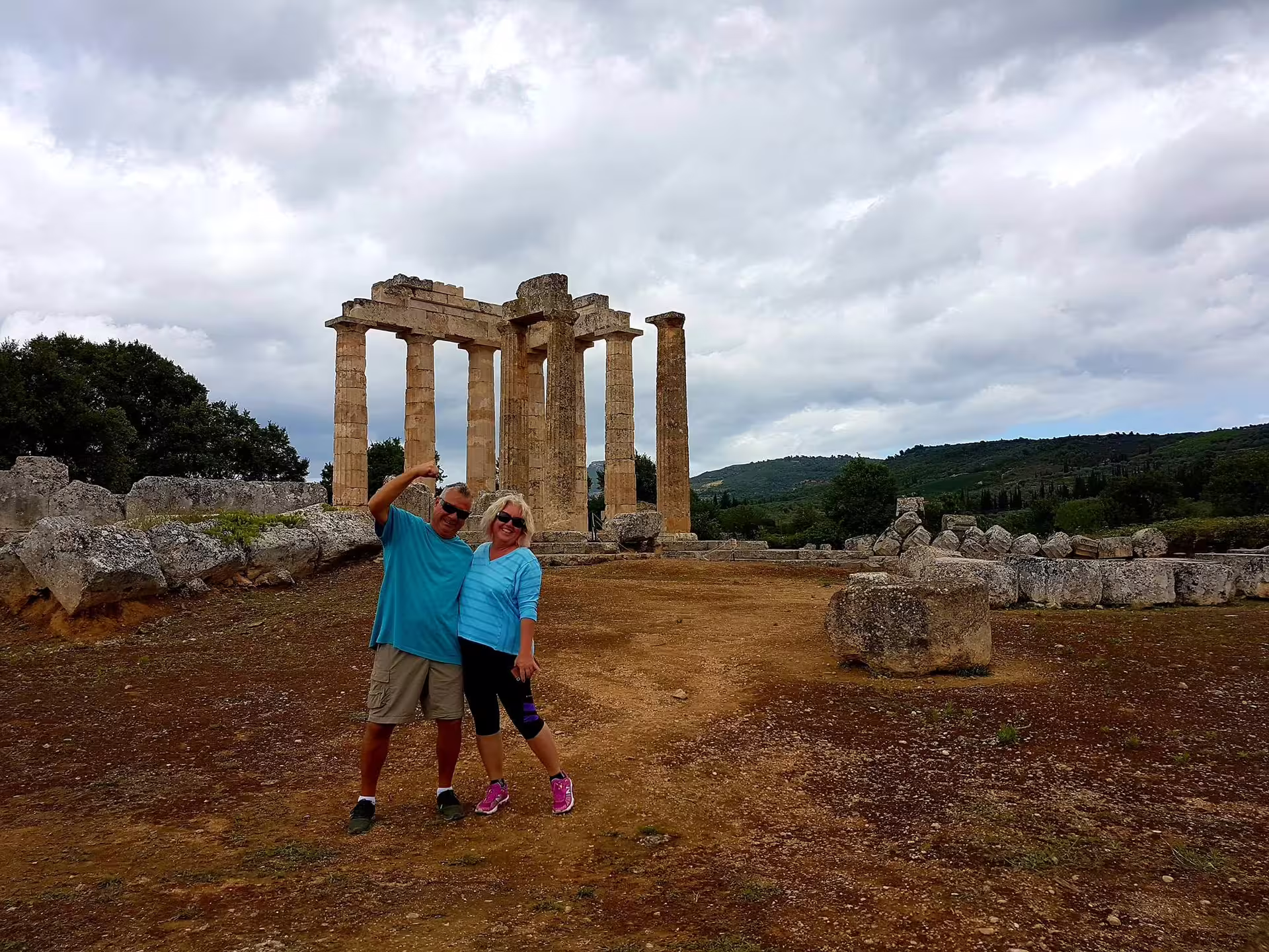 Travelers pose by the Temple of Apollo in Ancient Corinth on a private tour from Athens via Isthmus Canal