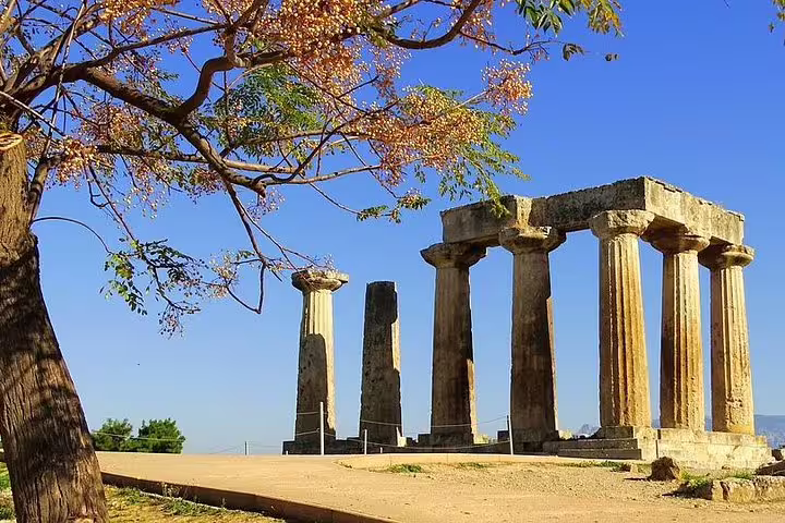Temple of Apollo ruins in Ancient Corinth under blue sky, scenic stop on Athens to Peloponnese private tour