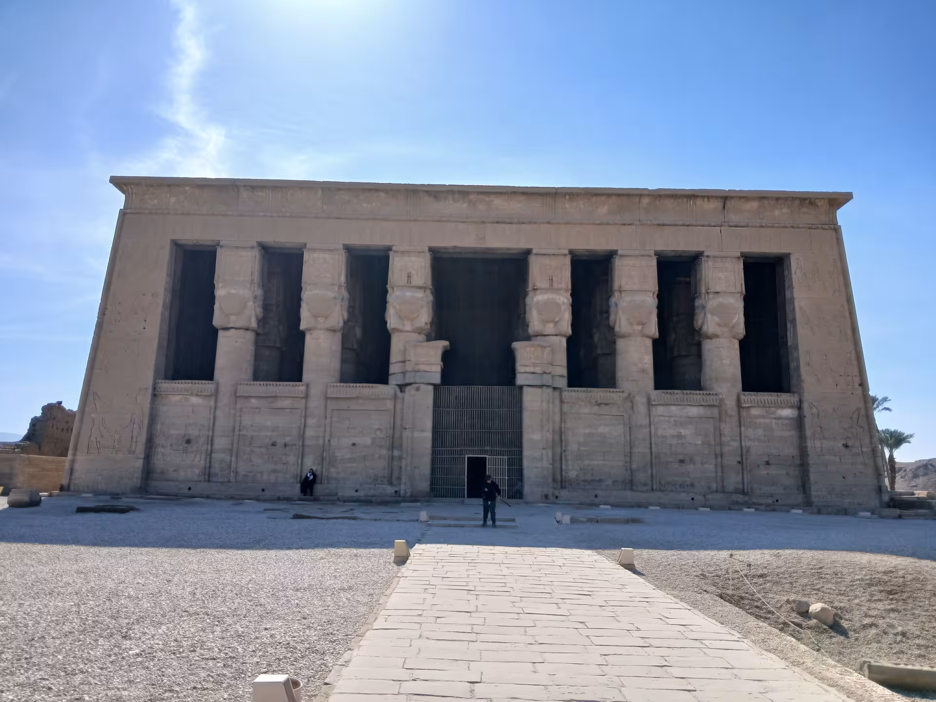 Explore the majestic facade of the ancient Temple of Hathor in Dendera under a clear blue sky.