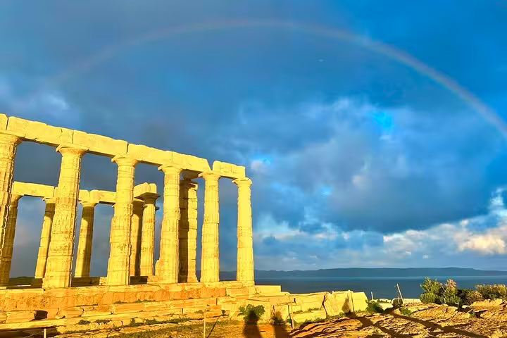 Temple of Poseidon at Cape Sounio glowing at sunset with rainbow, luxury private Athens Riviera tour